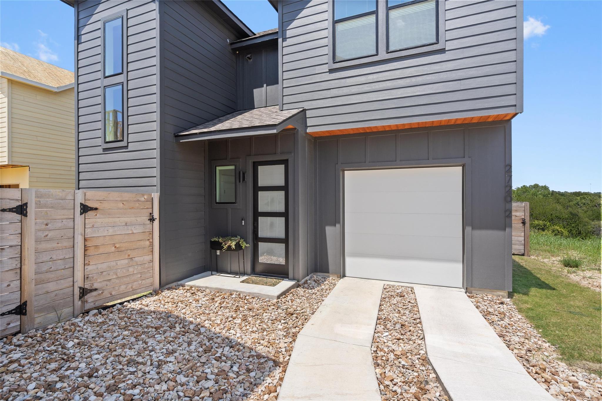 A modern facade with gray siding and large window