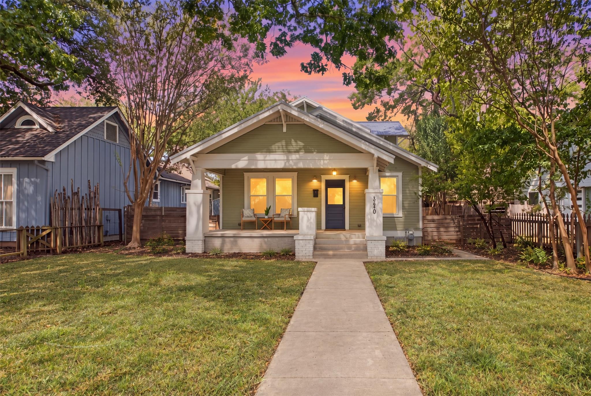 Mature trees frame a welcoming front porch and a 