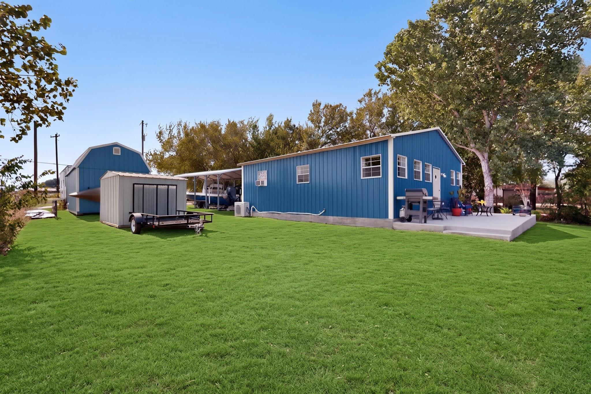 A spacious green lawn borders the structure, comp