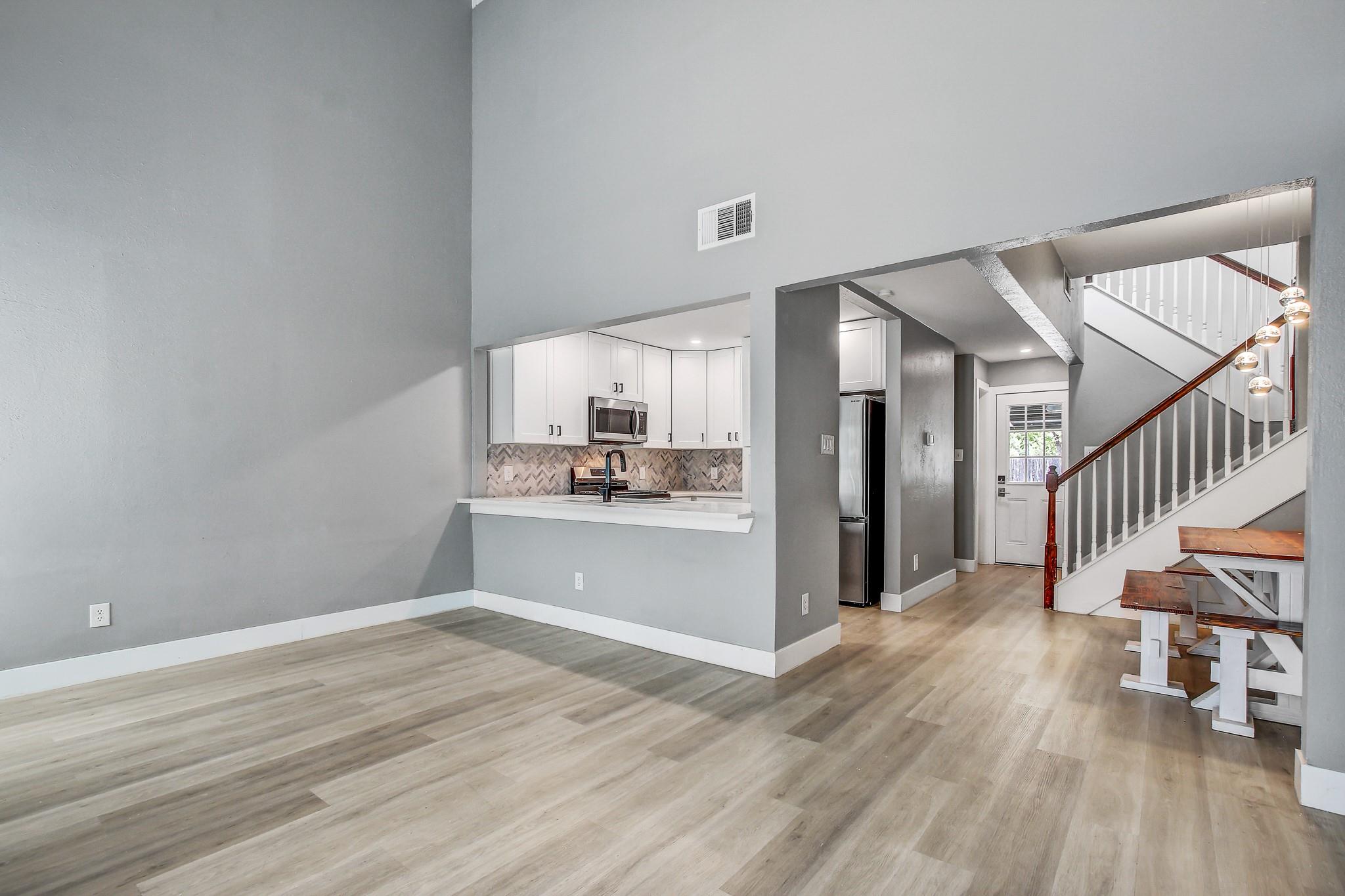 Unfurnished living room with a high ceiling, ligh