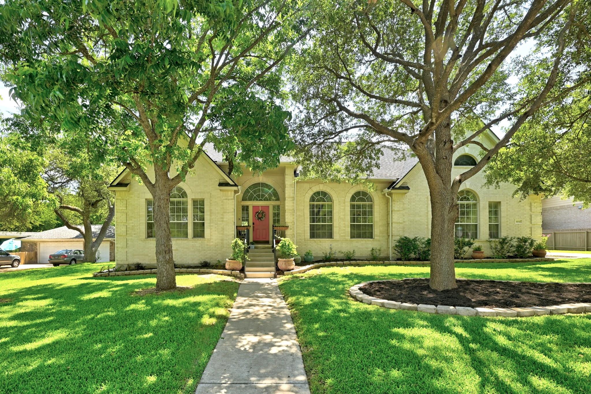 Mature trees shade a welcoming front path leading