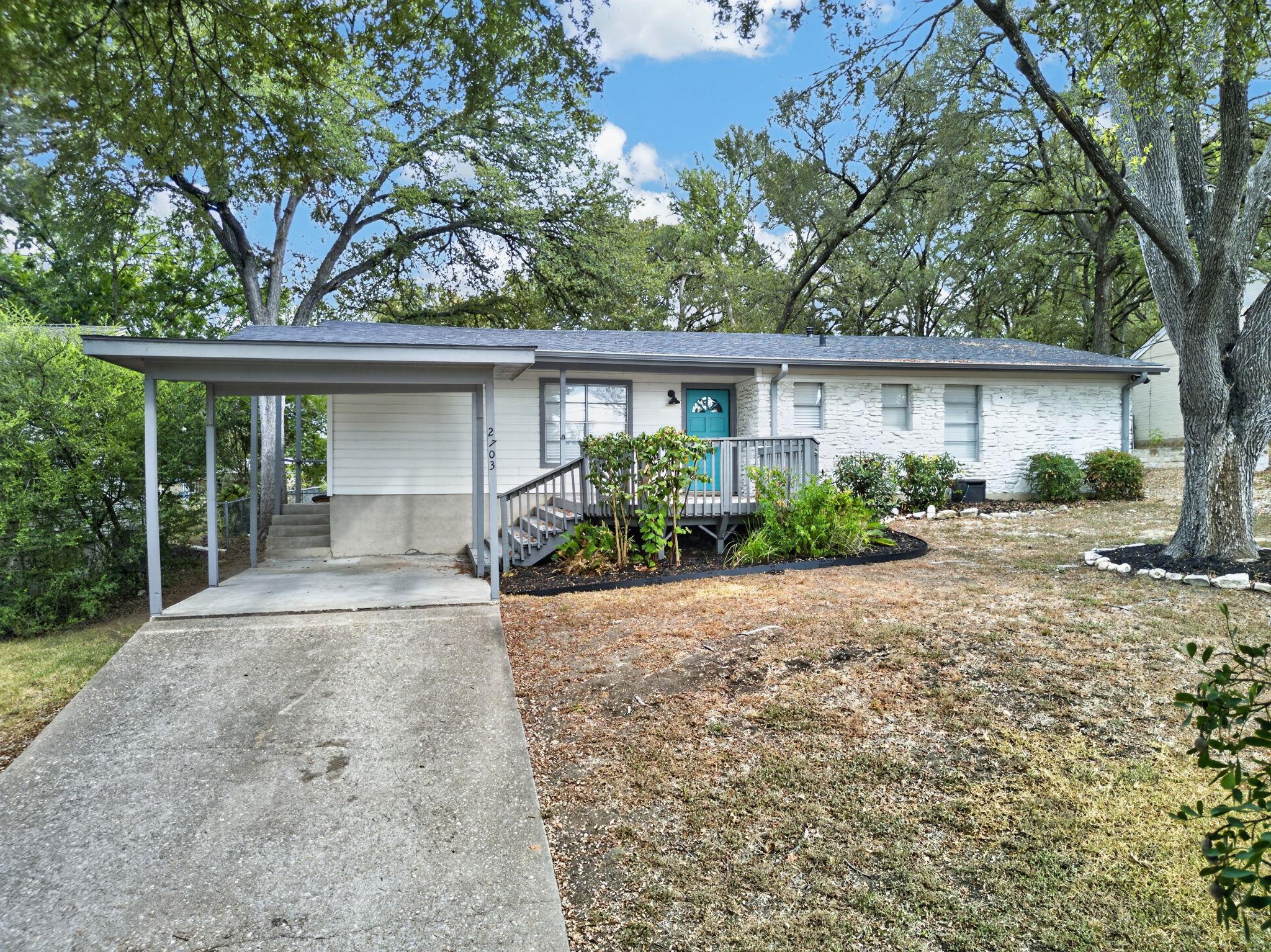Mature trees shade a classic single-story home fe