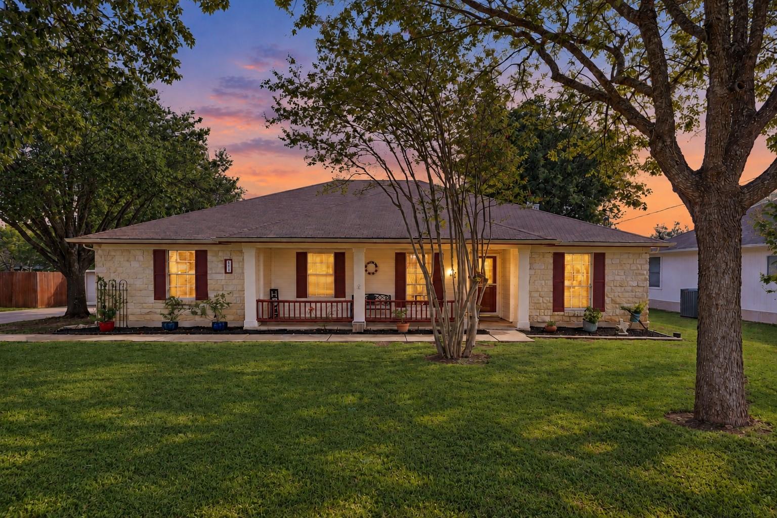 Mature trees shade a classic stone exterior front