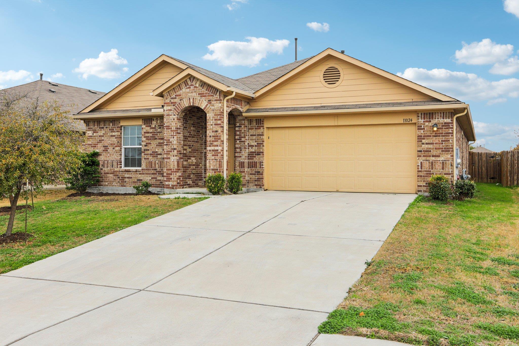 Classic brick accents and a spacious concrete dri