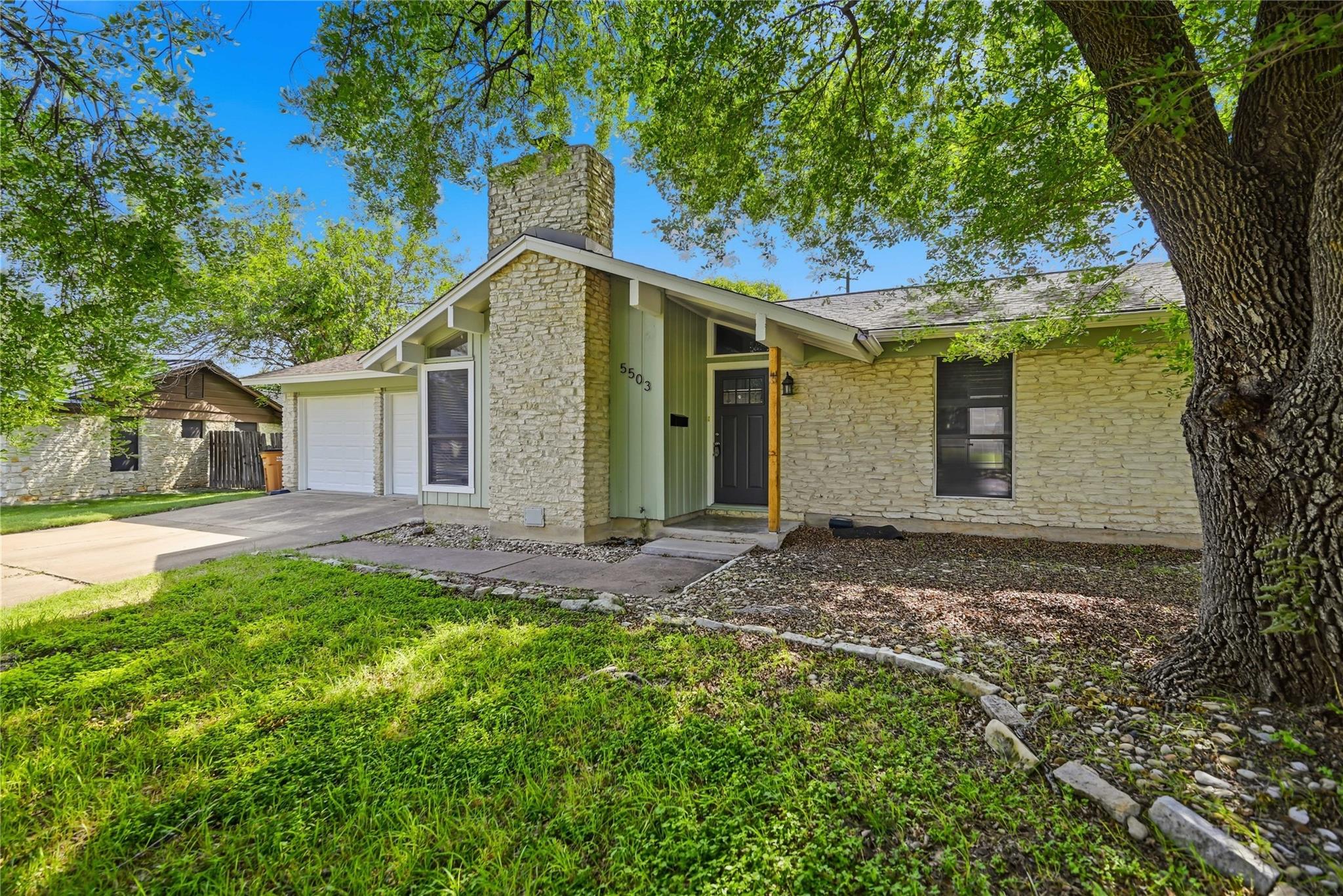 Mature trees shade a classic limestone exterior f