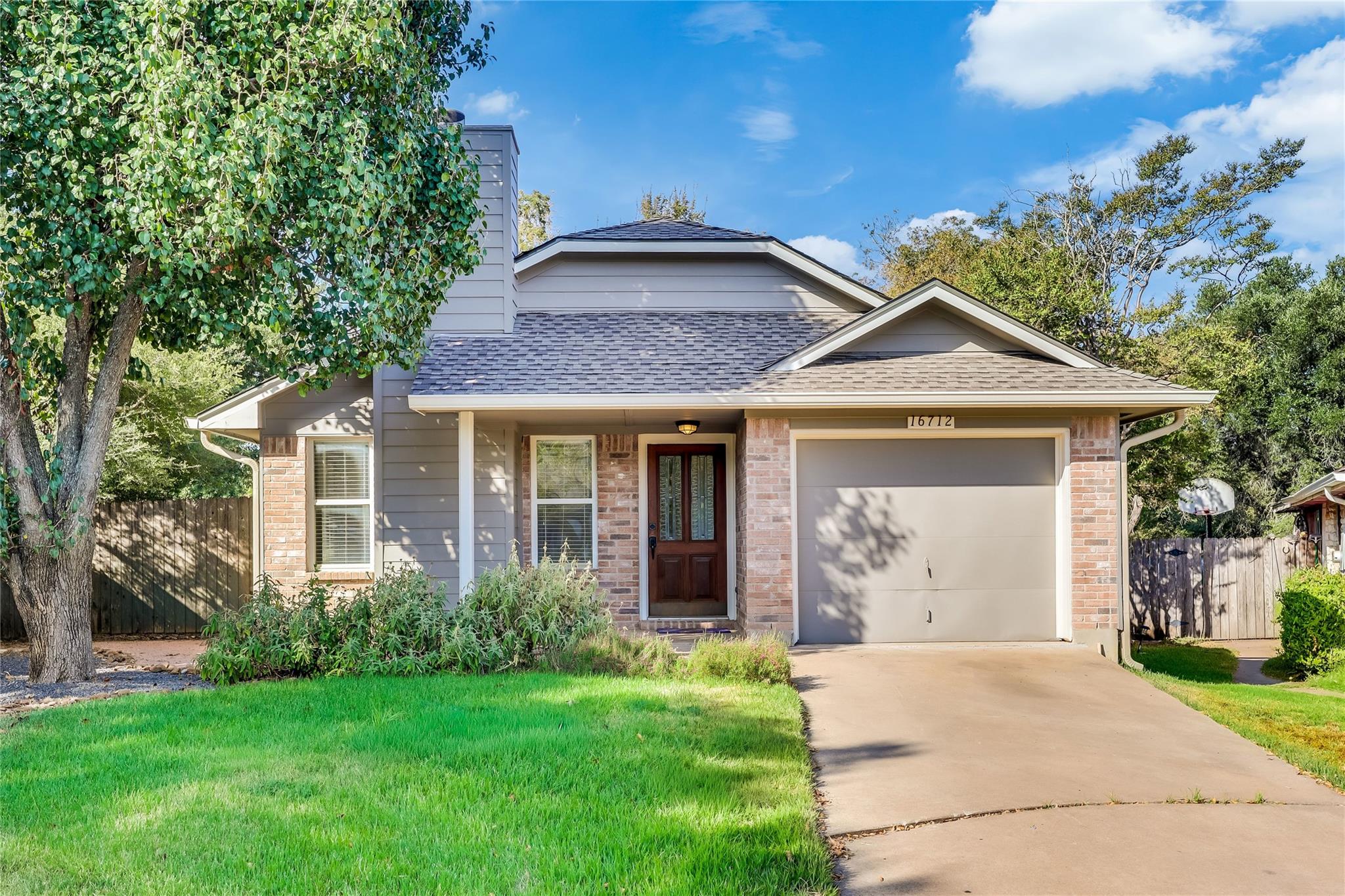 An inviting exterior features a concrete driveway