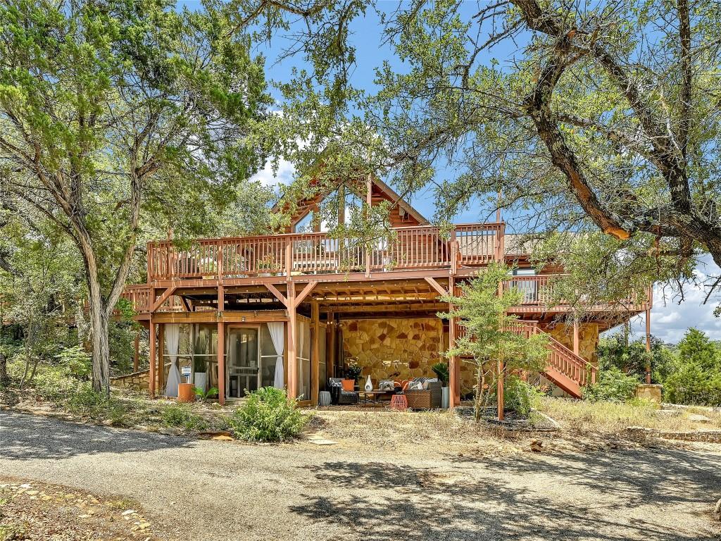 Mature trees frame a rustic multi-level home with