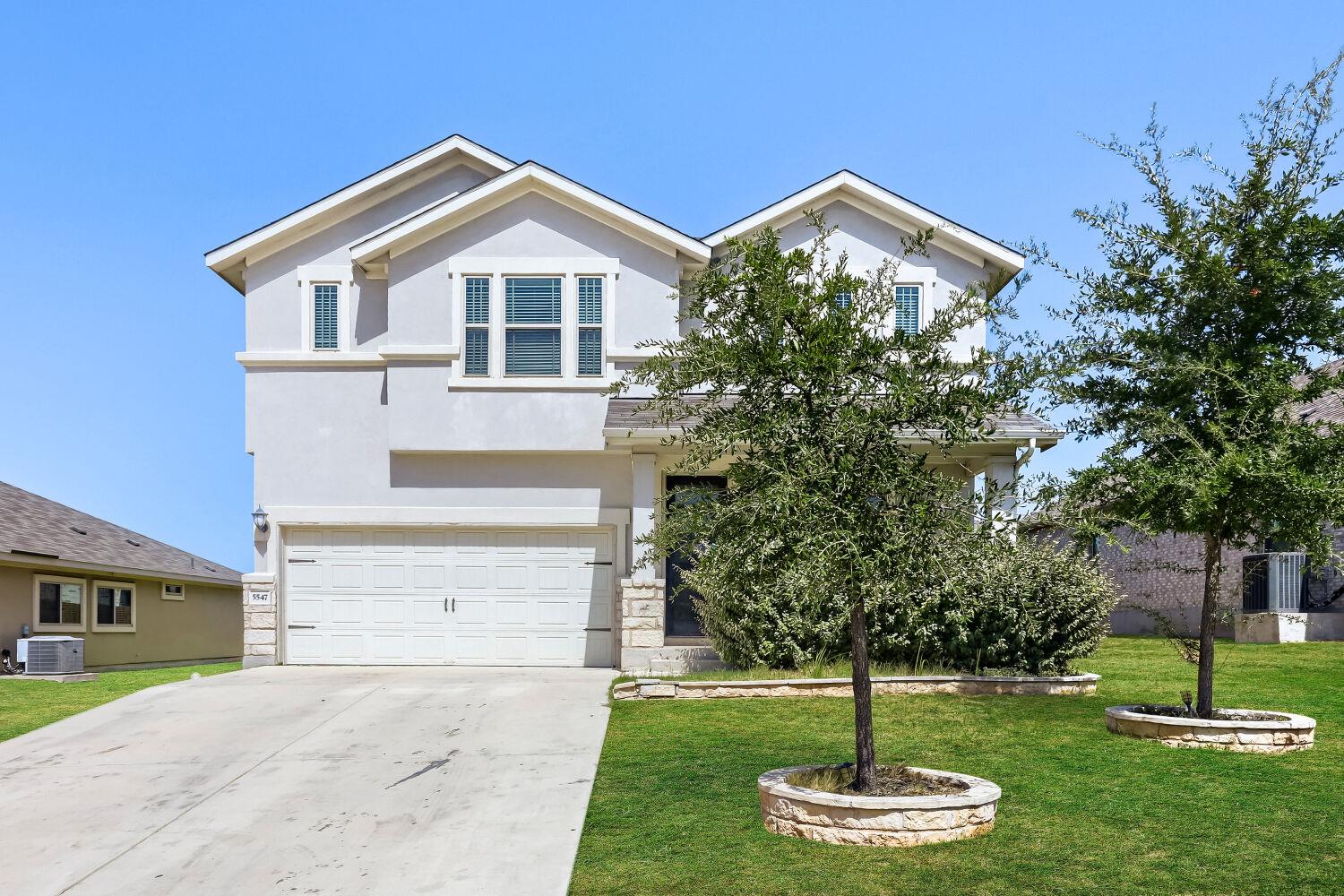 An attractive two-story elevation boasts stone ac