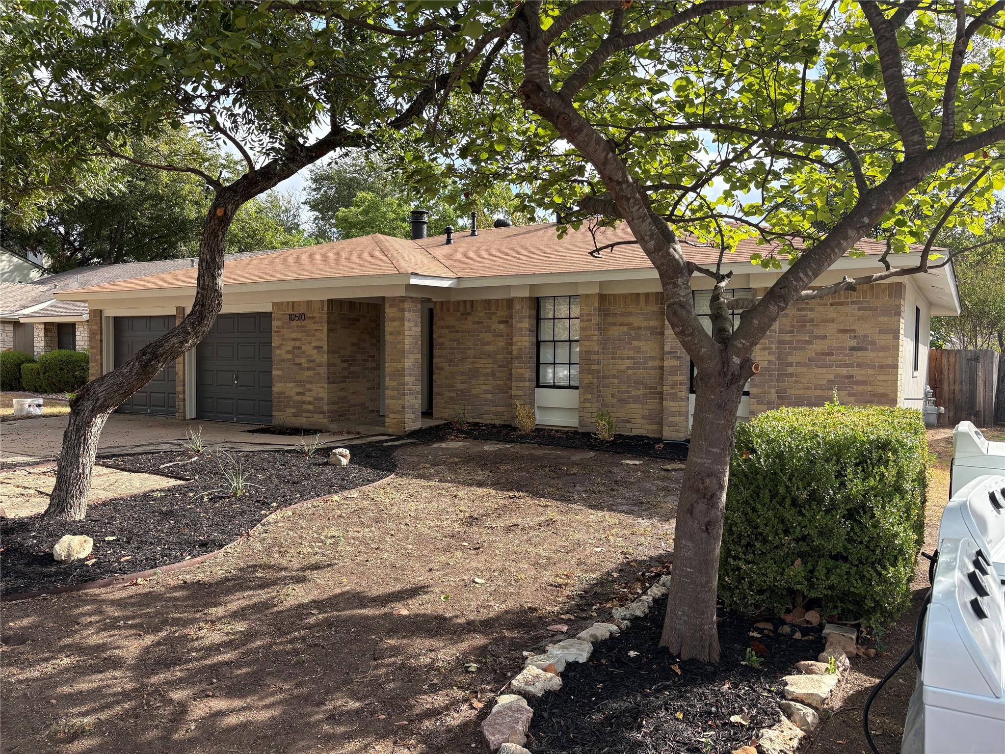 Mature trees shade the classic brick exterior of 