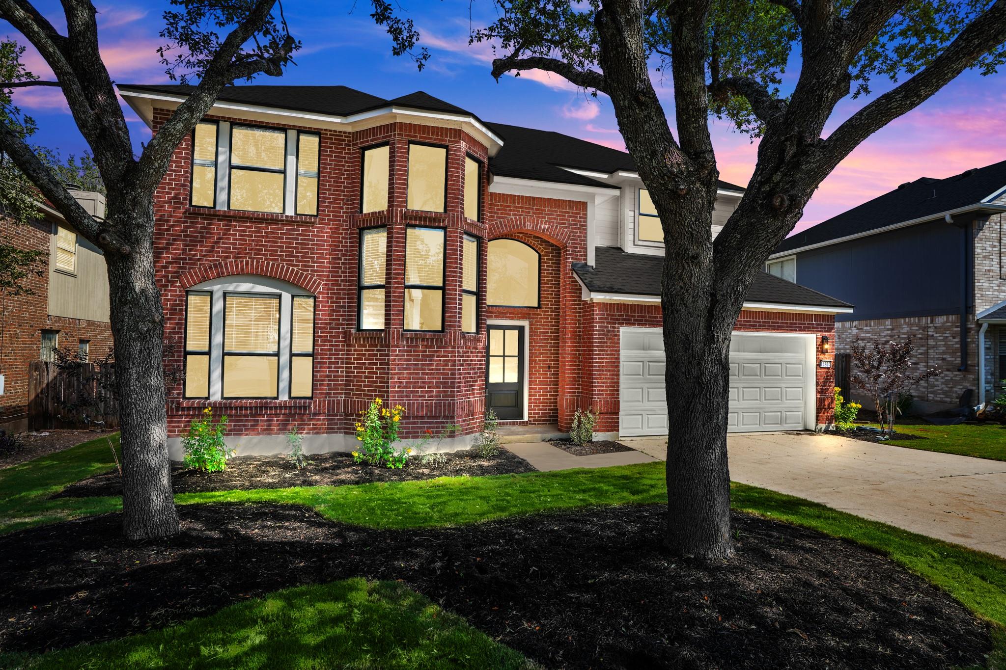 Mature trees frame the classic red brick exterior