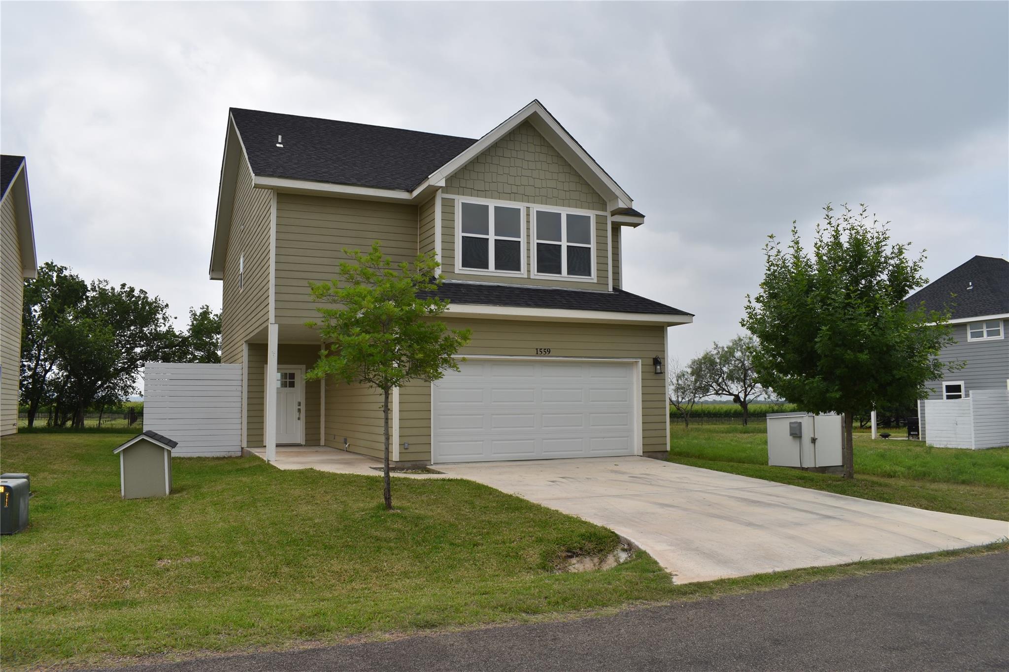 A concrete driveway leads to a front-loading two-