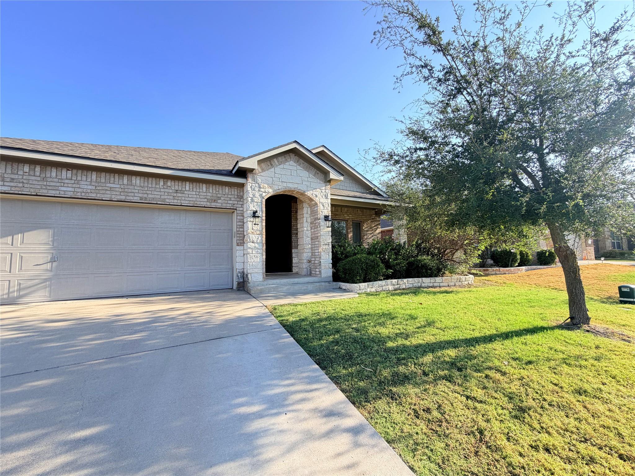 An inviting stone-accented entryway and wide conc