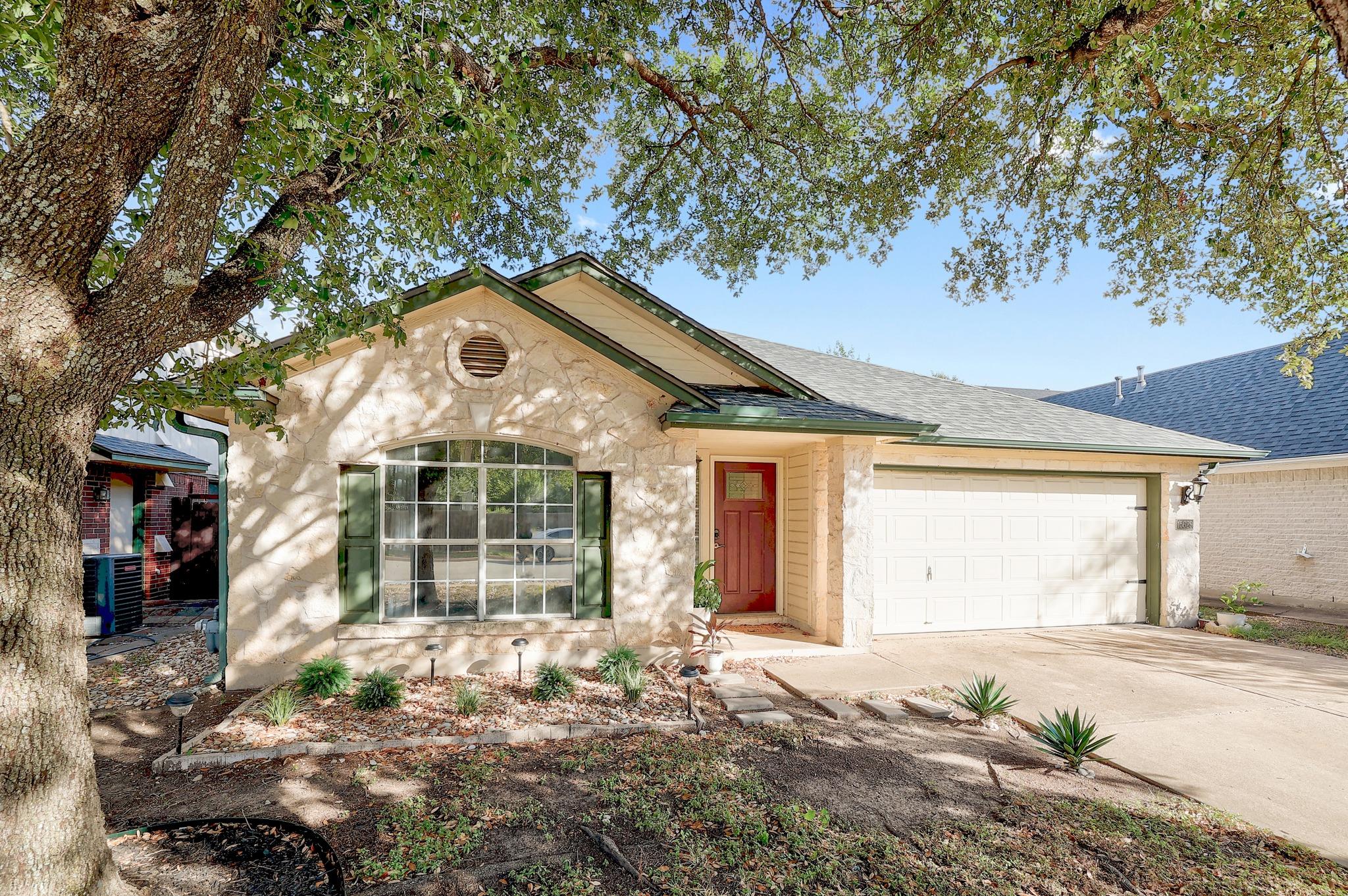 Mature trees shade a classic stone-veneer exterio
