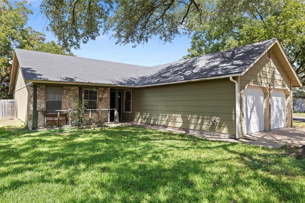 Mature trees shade a welcoming front lawn leading