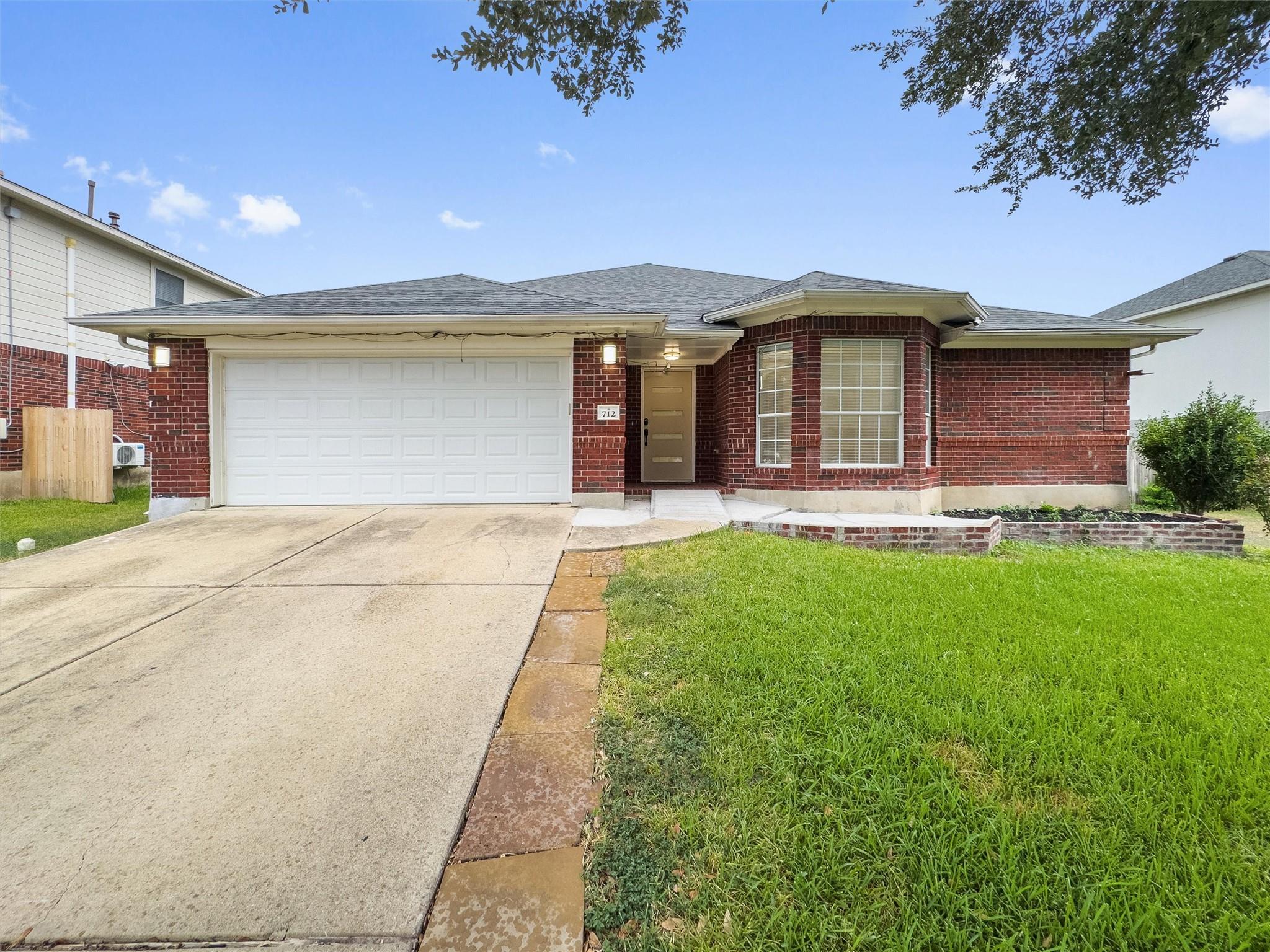 A classic brick exterior and concrete driveway de