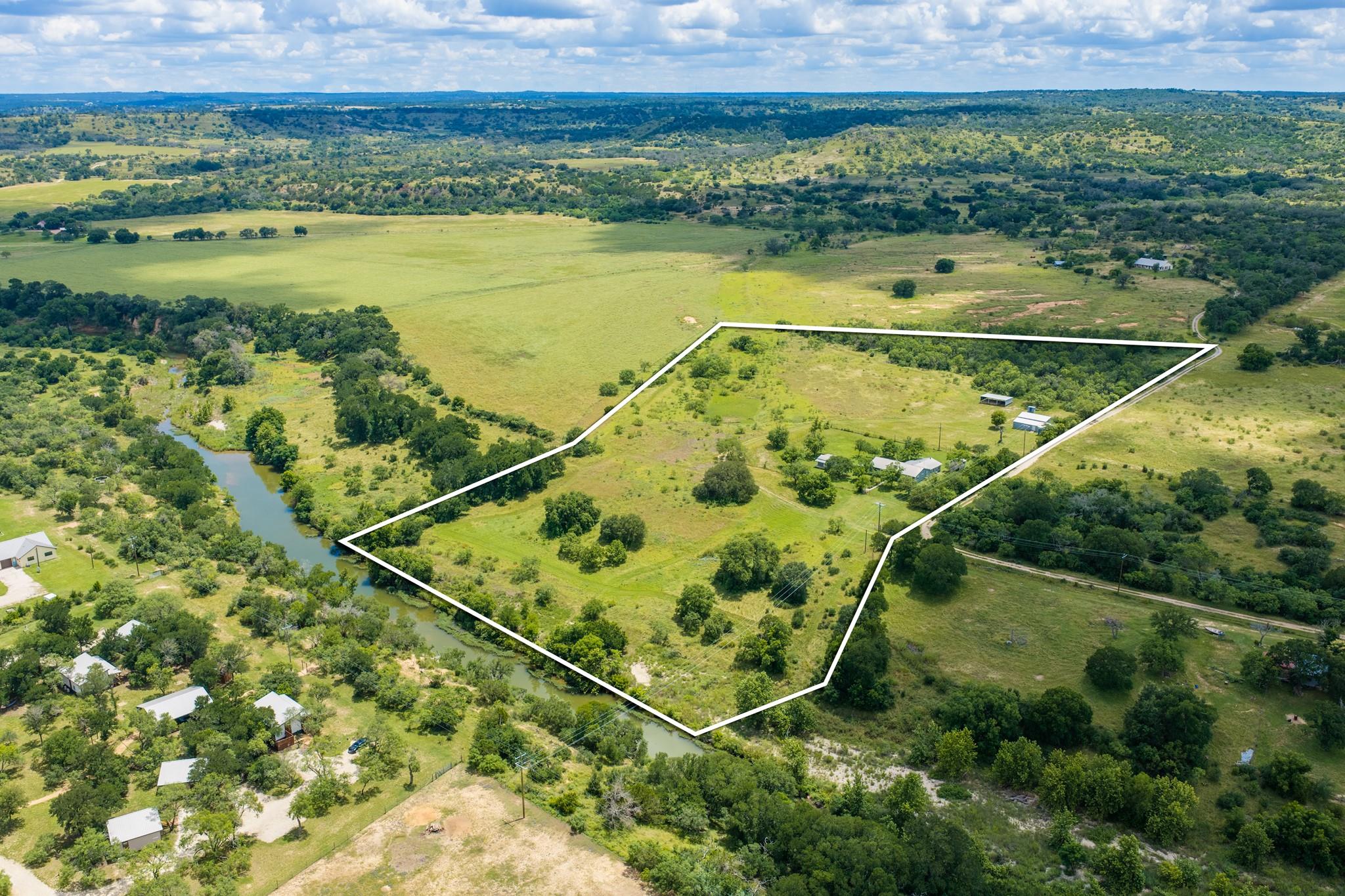 Lush rolling hills and a winding creek outline th