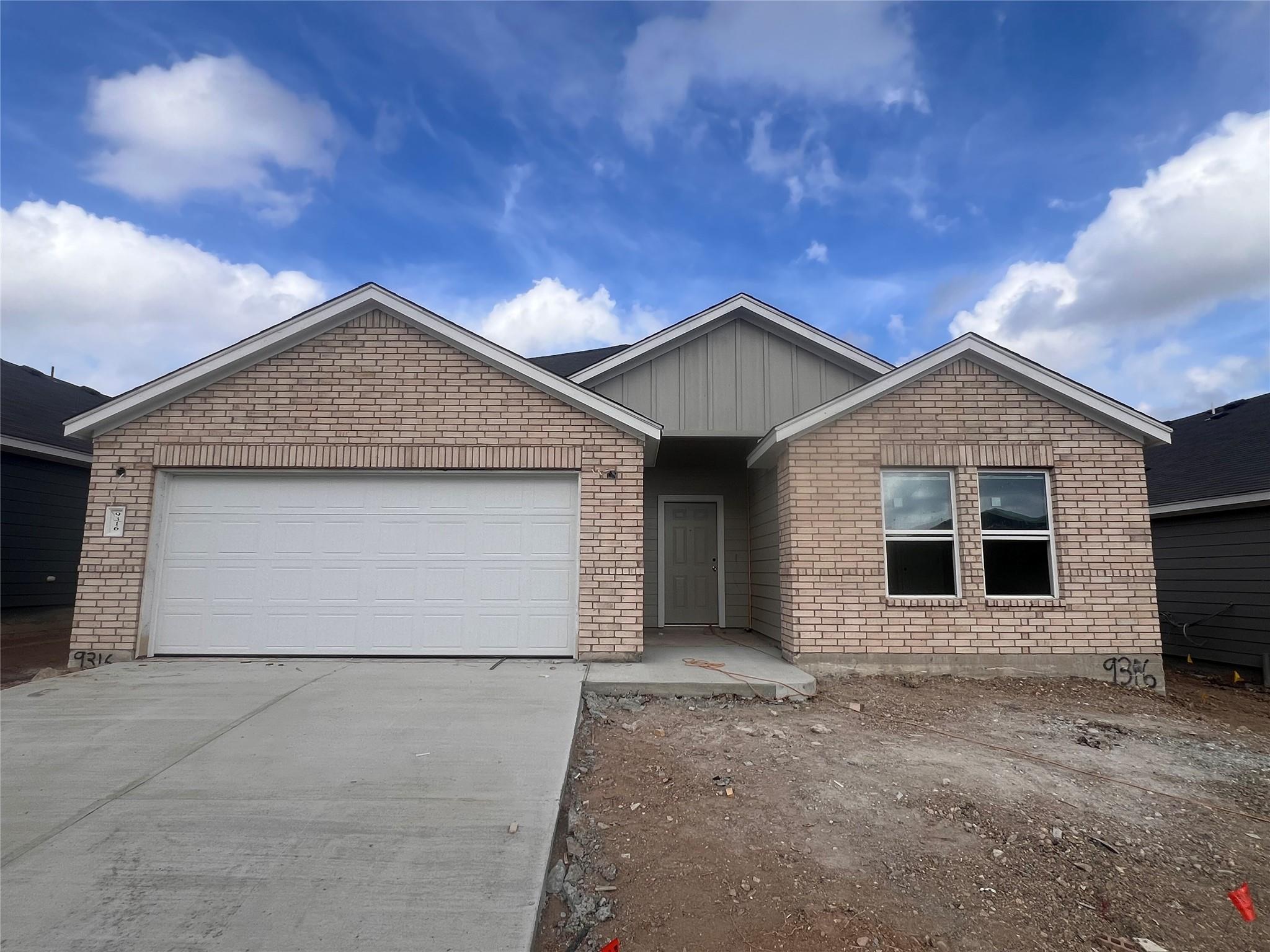 Brick siding and a concrete driveway define this 