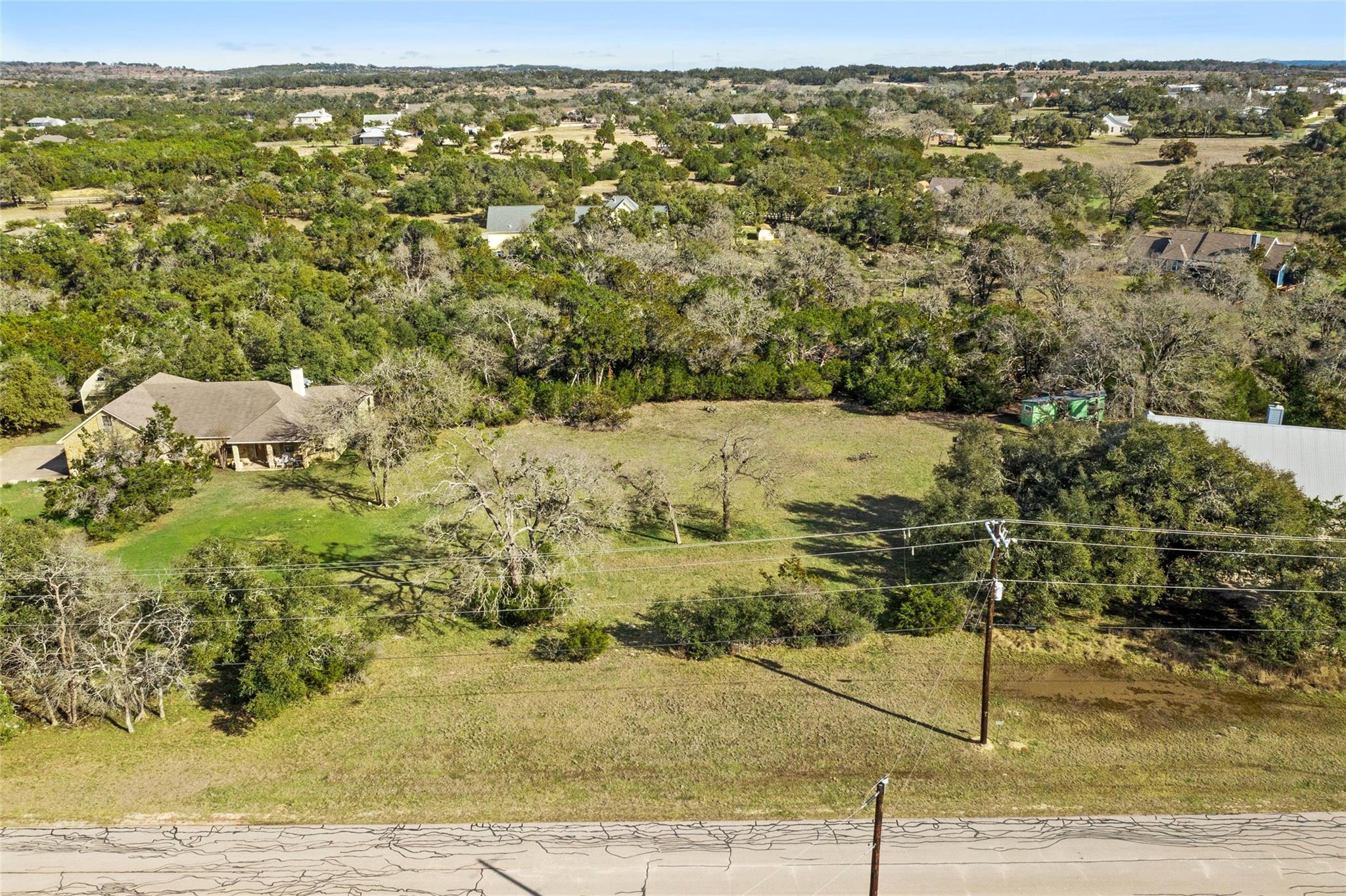Mature trees frame a spacious, open clearing bord