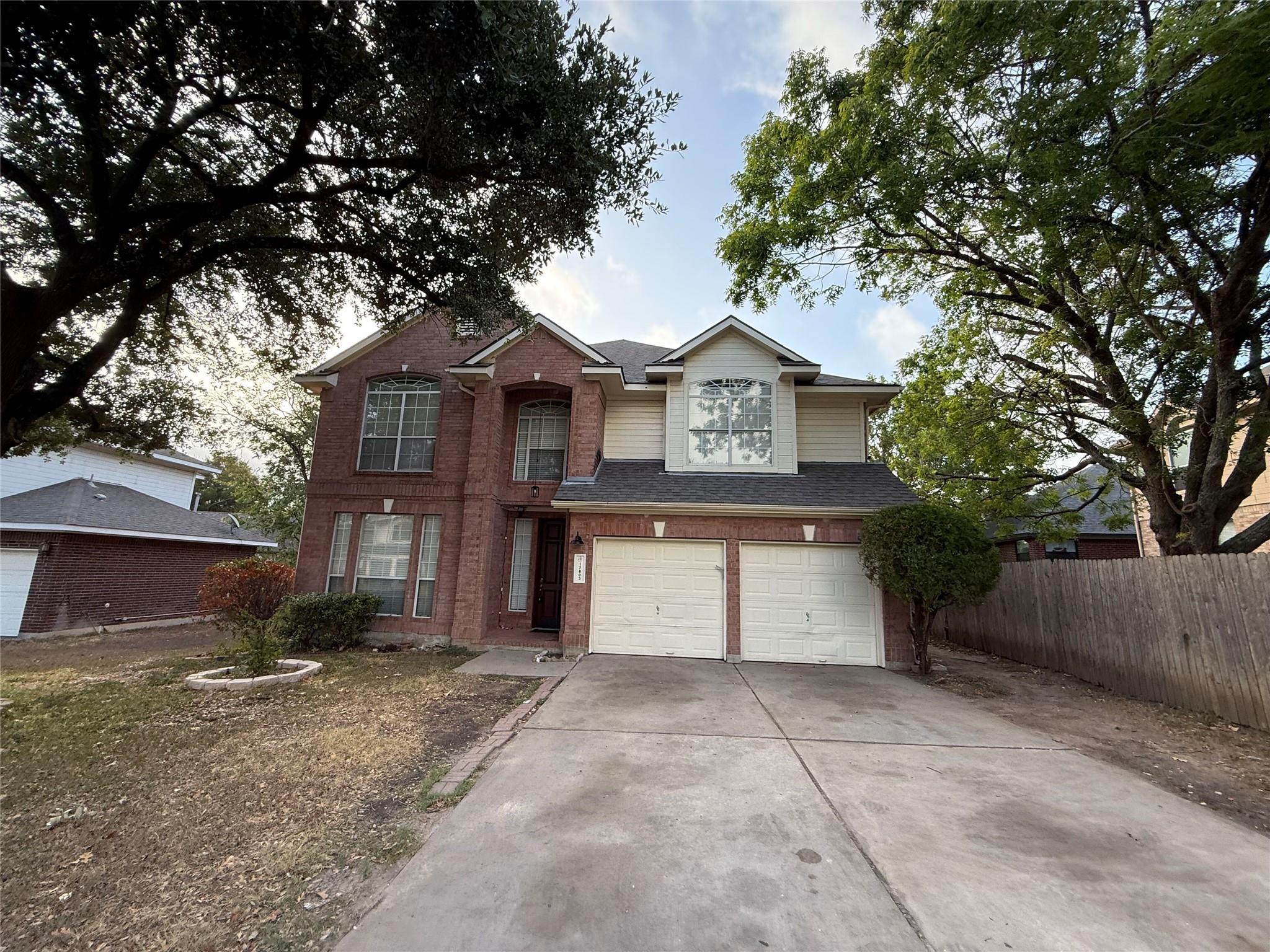 Mature trees frame a classic brick exterior with 