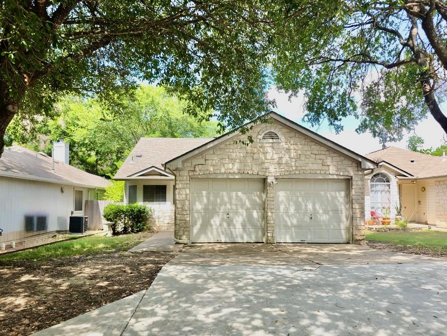 Mature trees shade a classic stone-veneer exterio