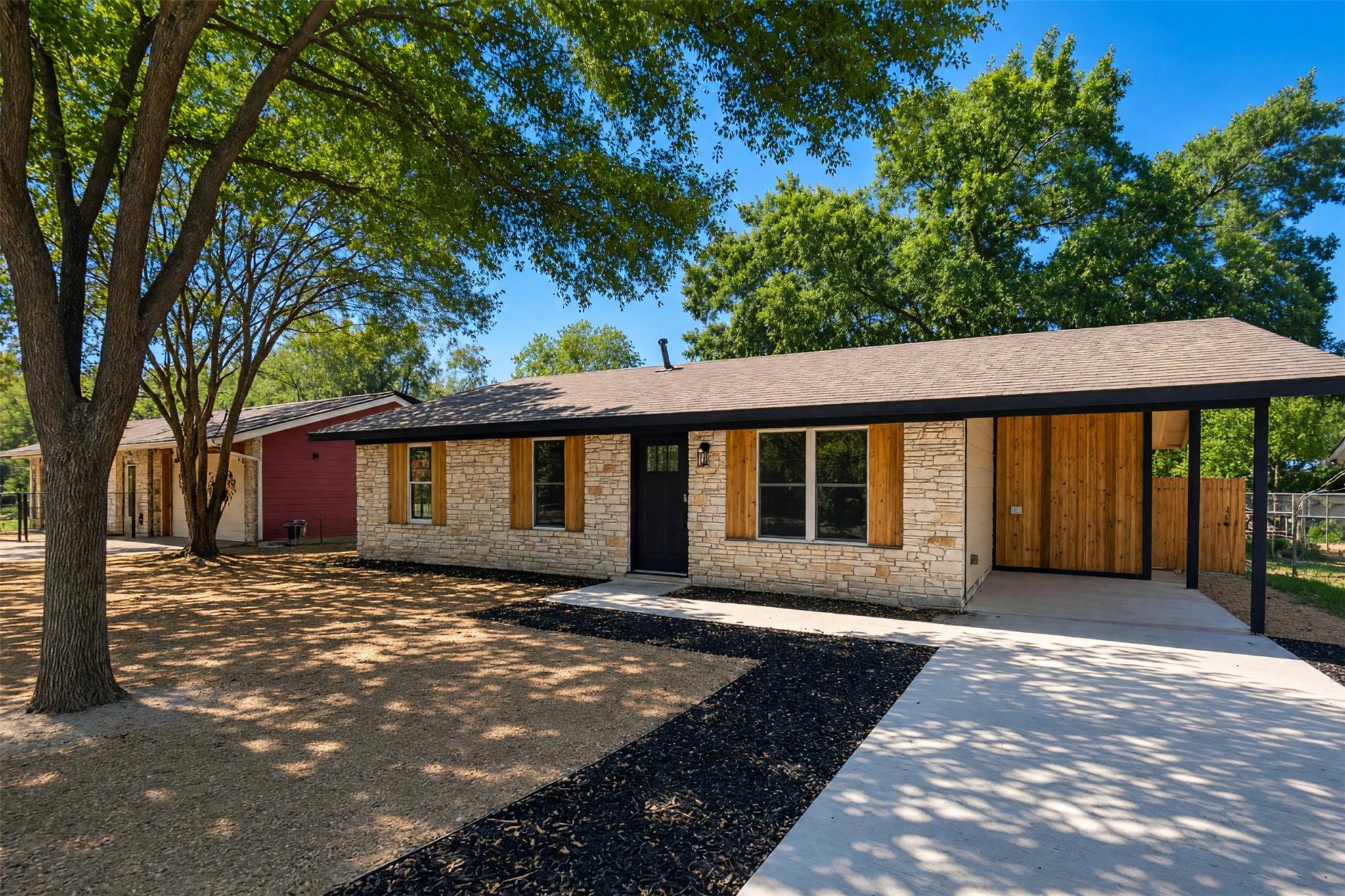 Mature trees shade a single-story home featuring 