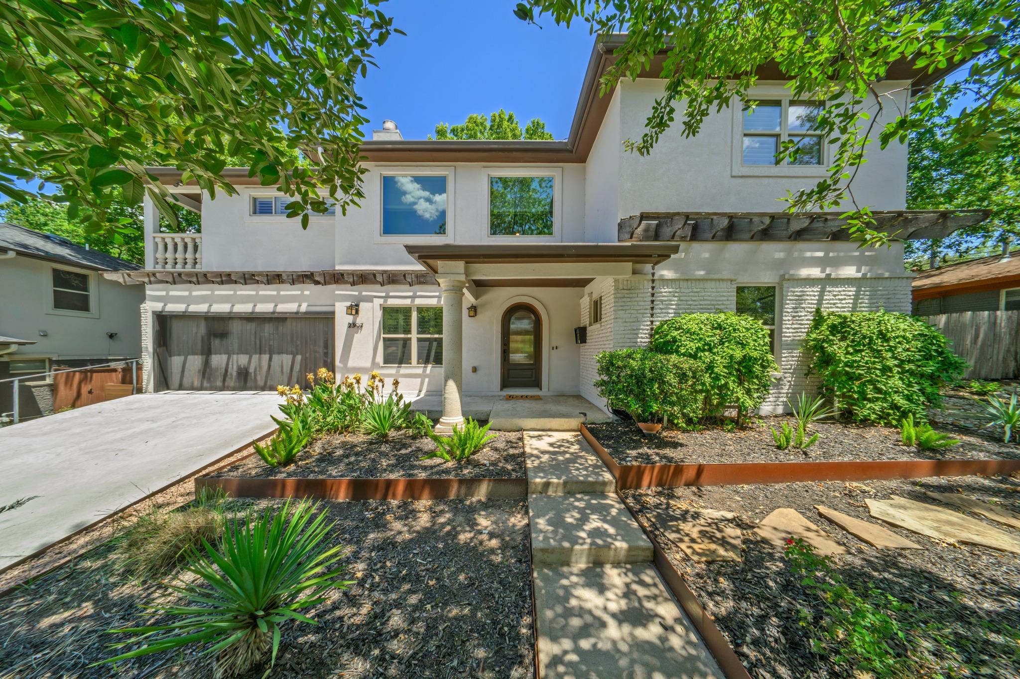 Lush landscaping frames the entry walkway of this