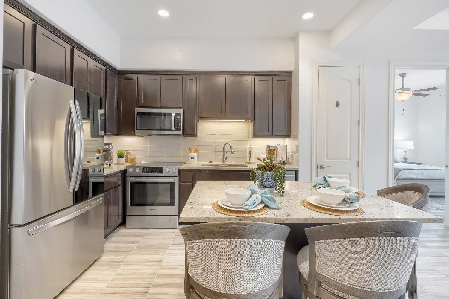 Rich dark cabinetry and stone countertops anchor 