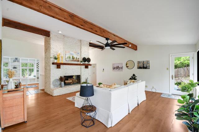 Living area featuring a large fireplace, light wo
