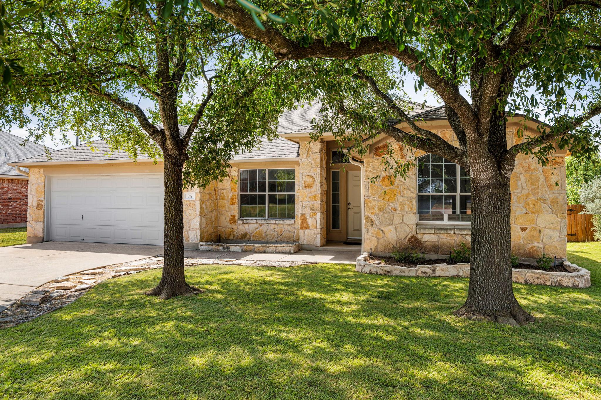 Mature trees shade a classic stone exterior with 