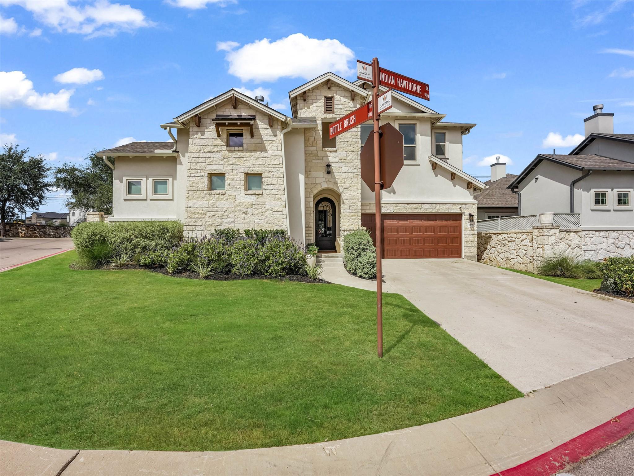 Natural stone accents and neat landscaping define