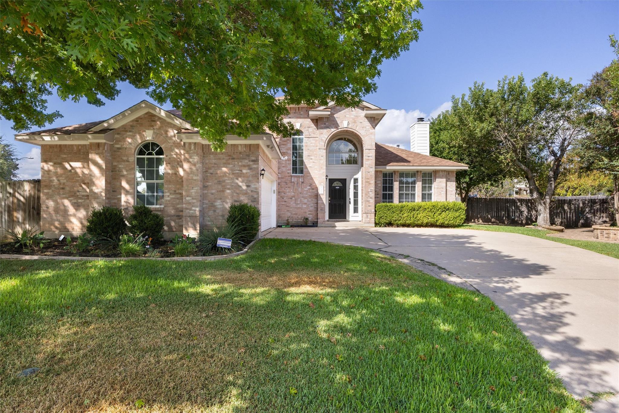 Mature trees shade a classic brick exterior with 