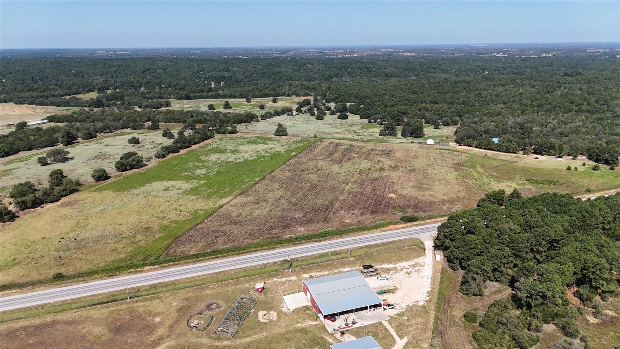 Vast acreage unfolds with open pastures, dense tr