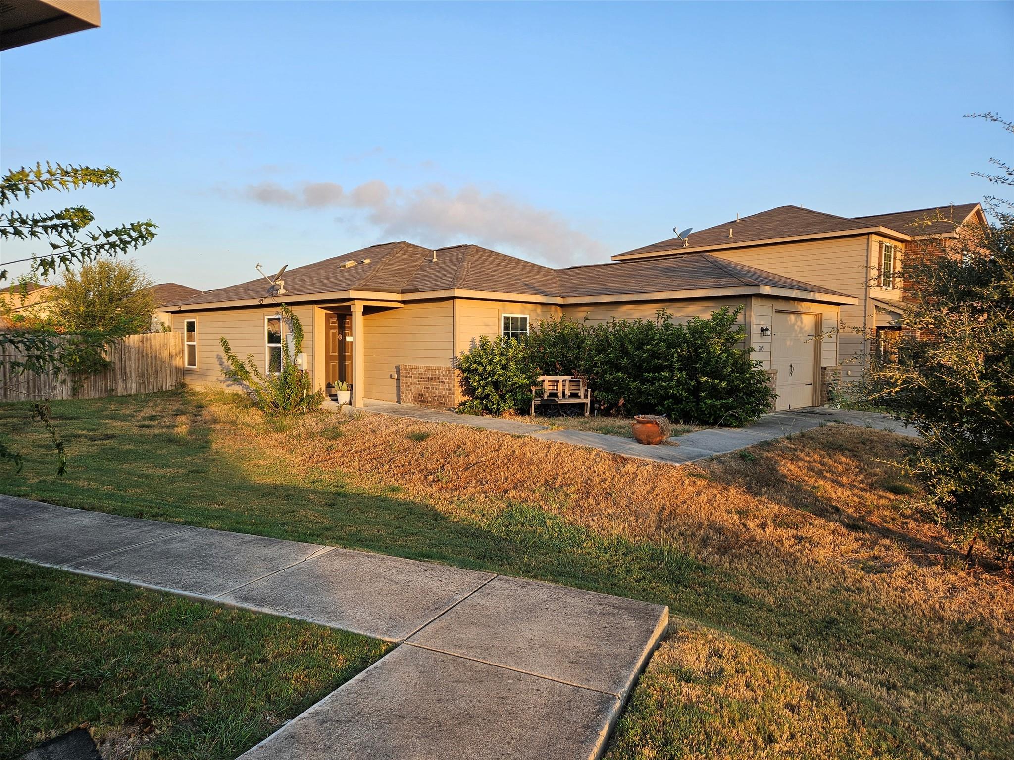 A concrete walkway leads past the grassy lawn to 