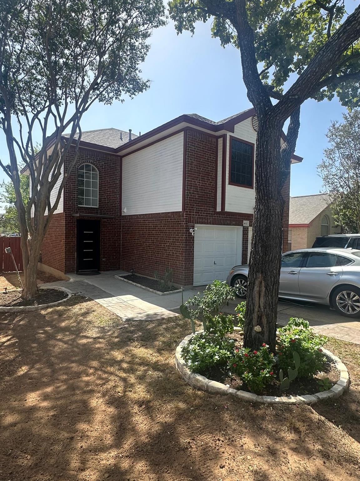 Mature trees shade the brick and siding exterior 