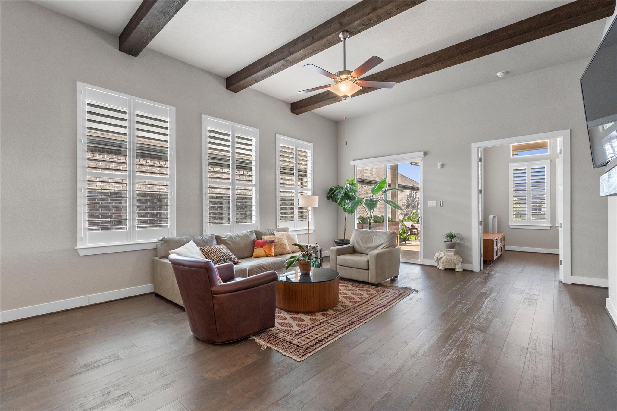Exposed ceiling beams and rich wood floors anchor