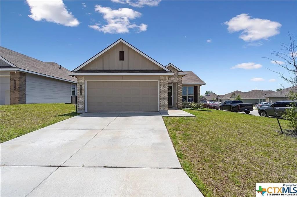 A wide concrete driveway leads to the front-entry