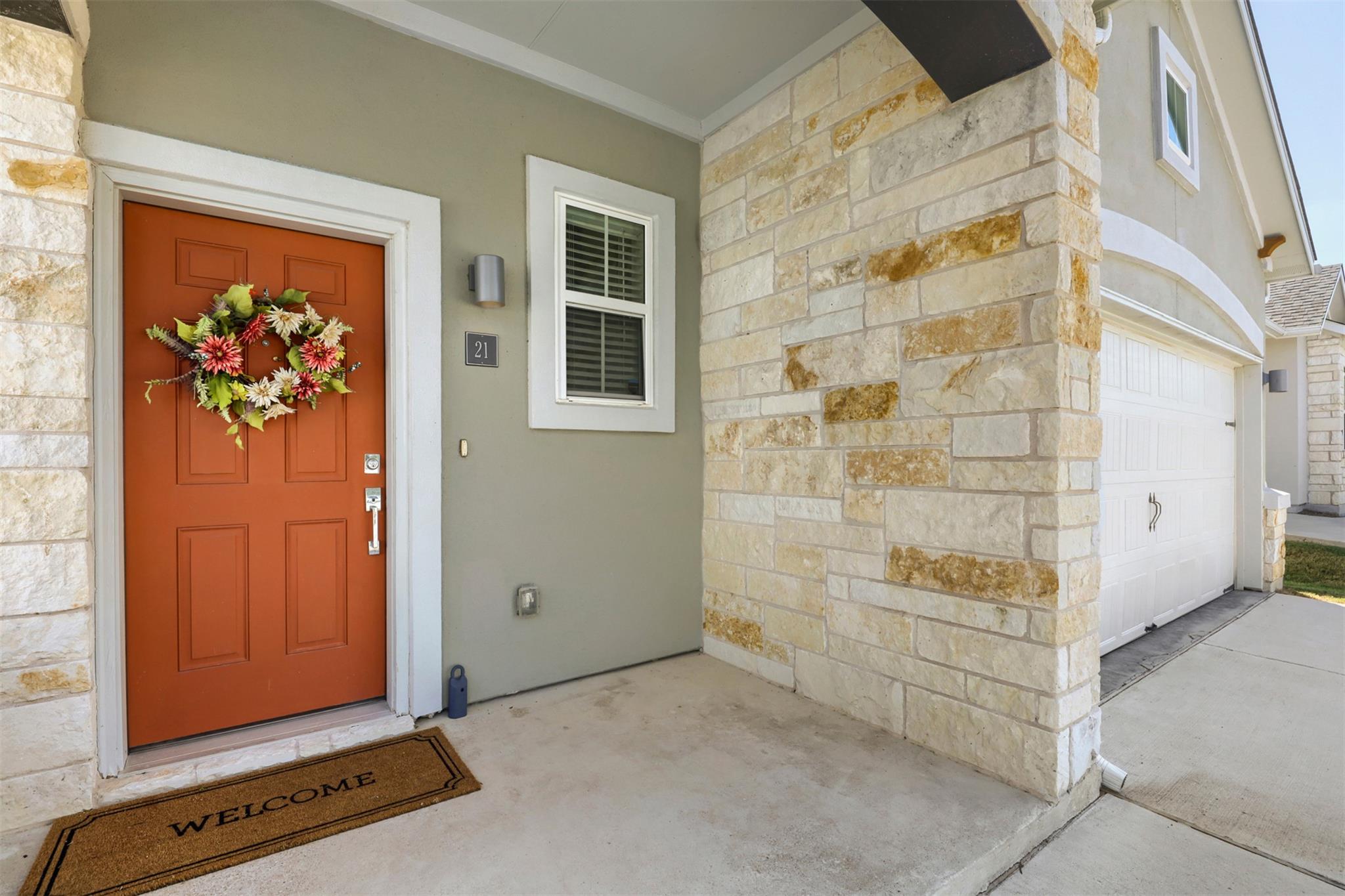 A welcoming front entry features textured stone a