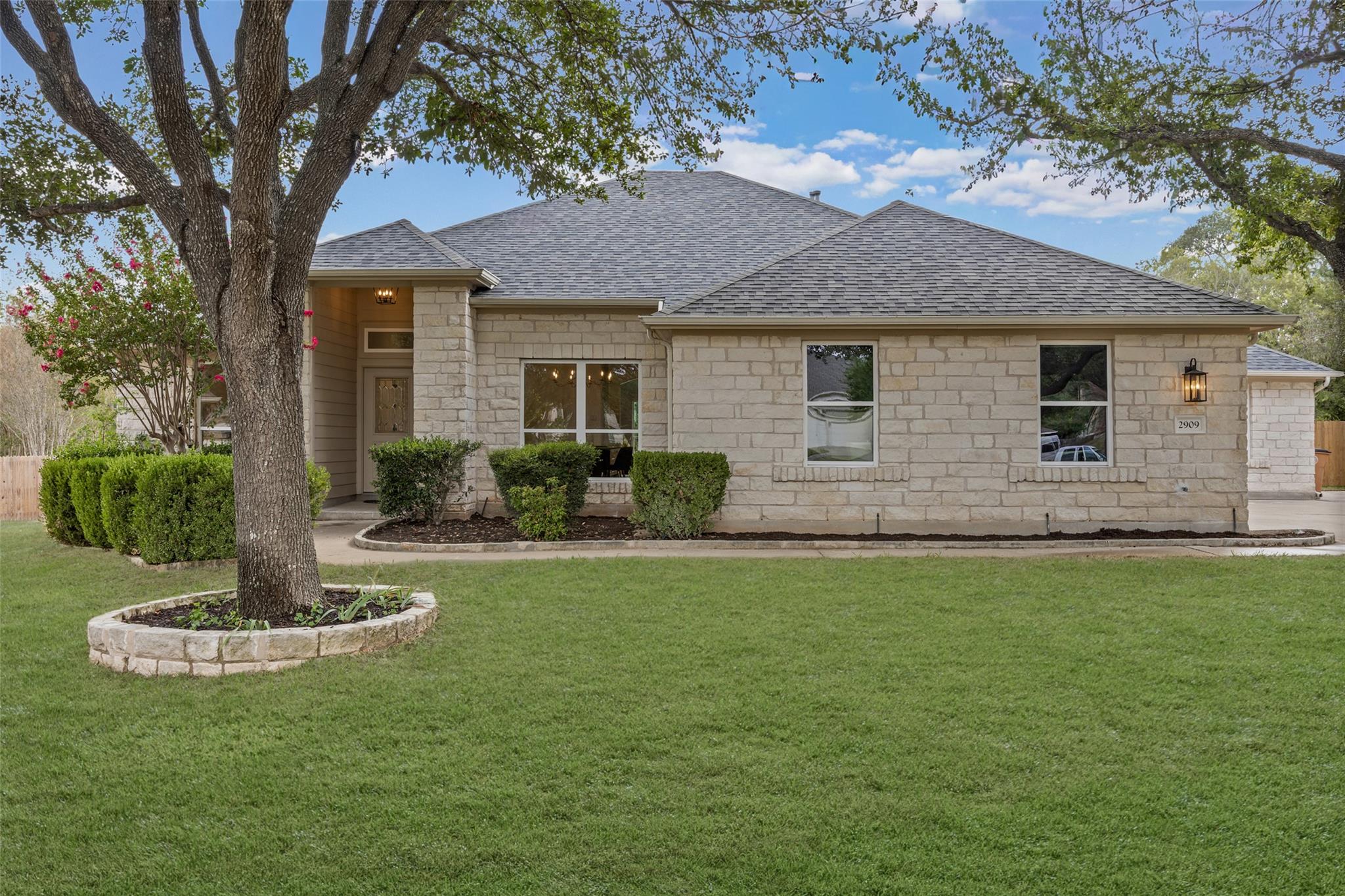 An inviting stone exterior pairs with a manicured