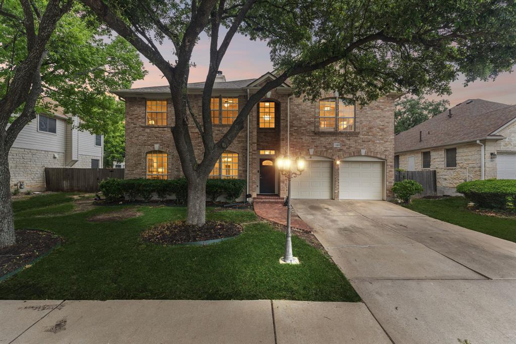 Mature trees frame a classic brick exterior with 