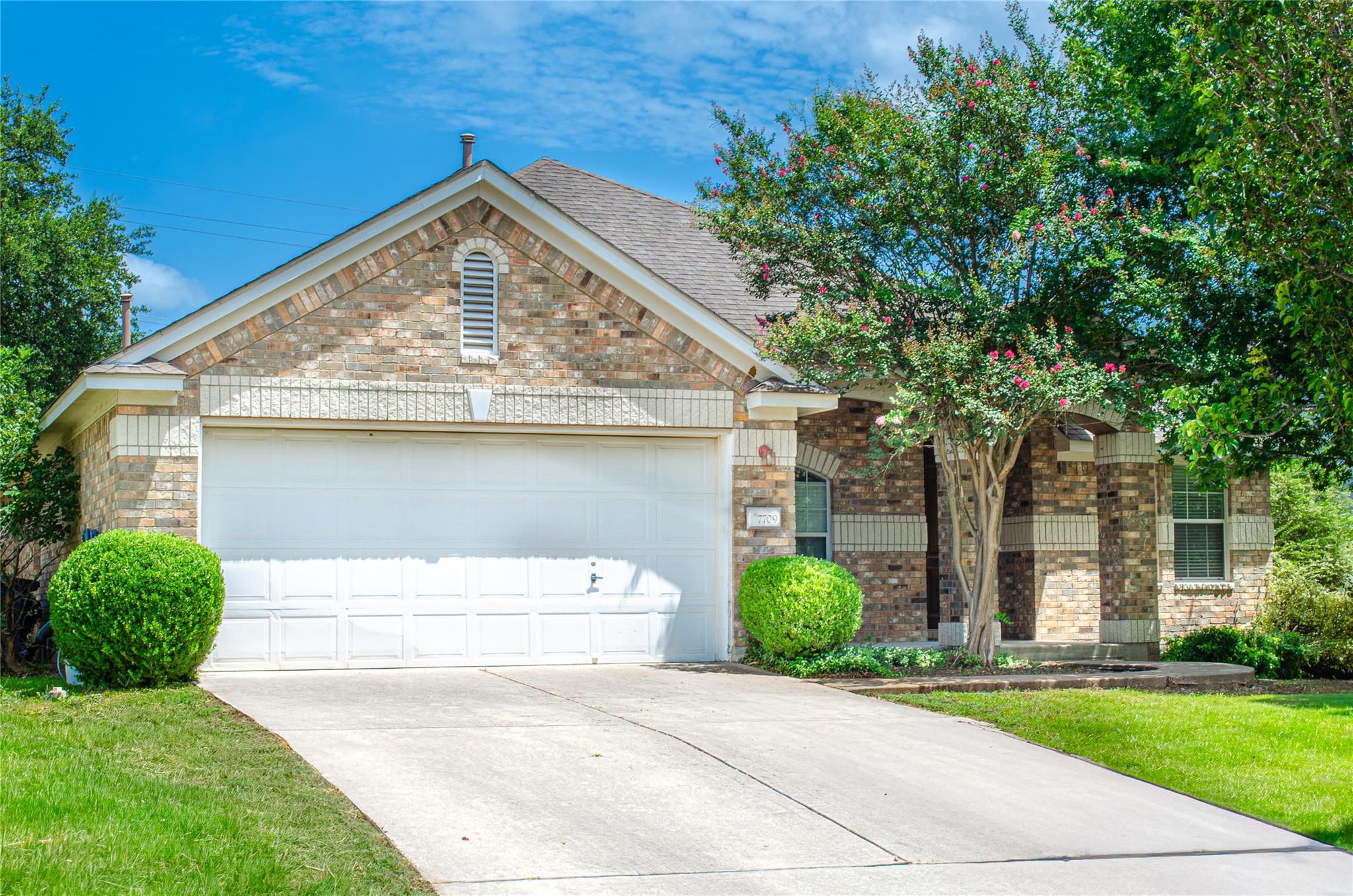 A classic brick facade and neatly kept lawn enhan