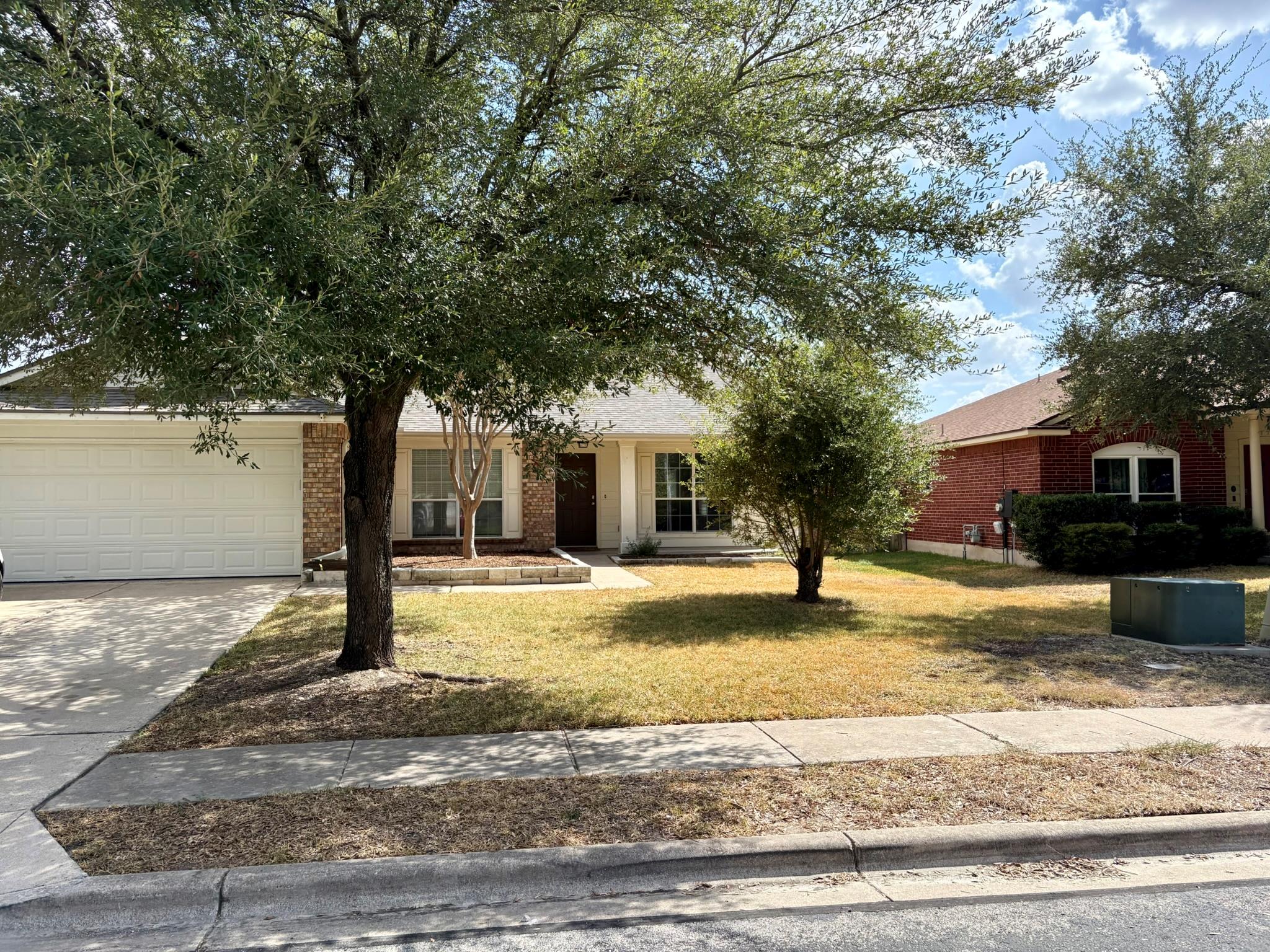Mature shade trees frame the welcoming entrance a