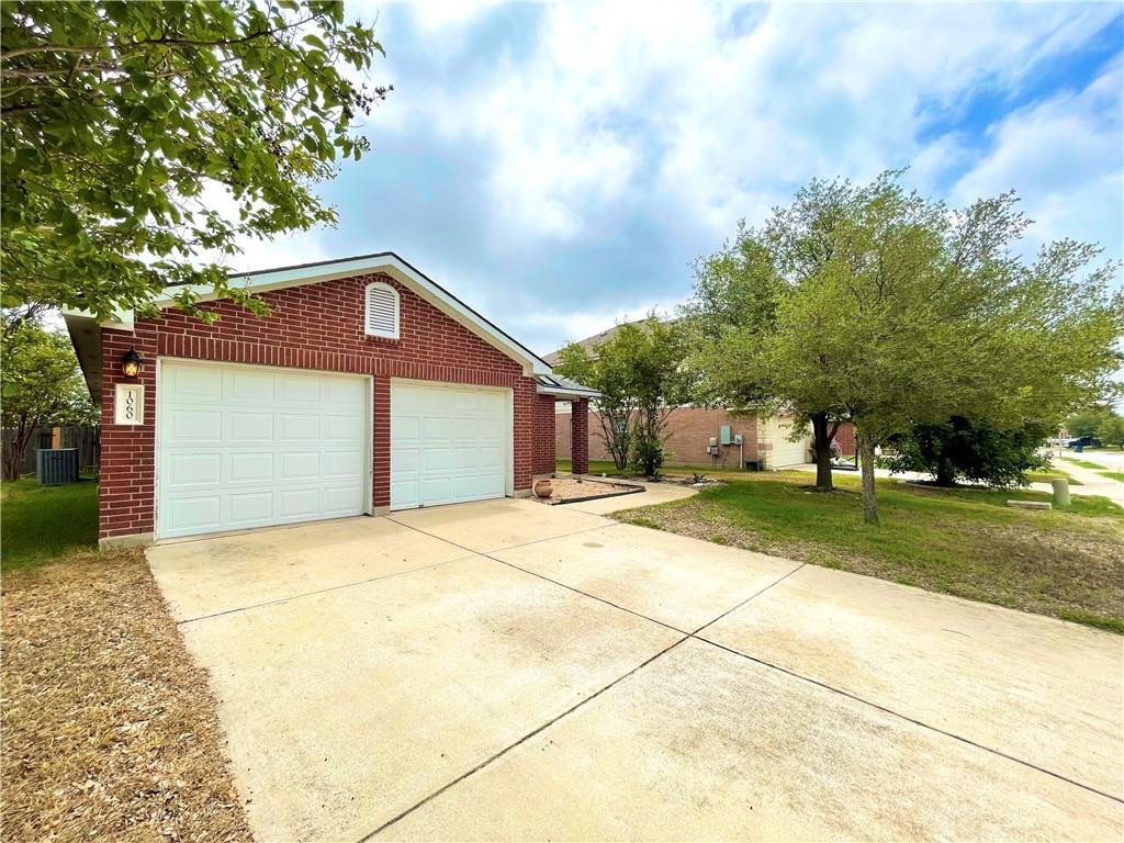 Classic brick accents and a spacious concrete dri
