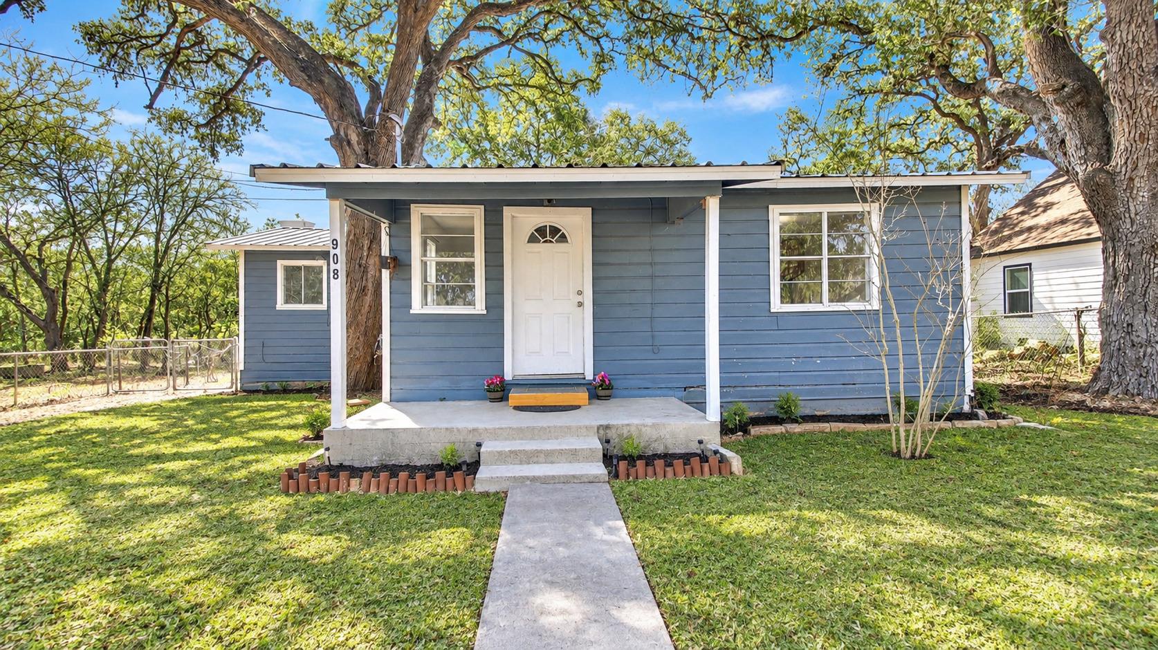 A concrete walkway leads to the covered front por