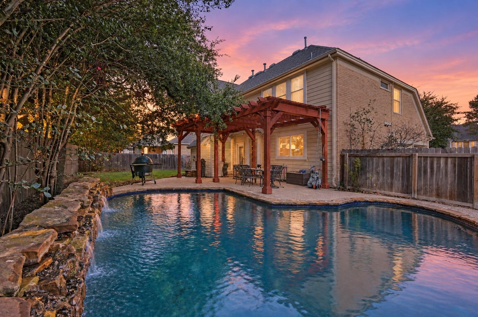 An inviting backyard oasis features a swimming po