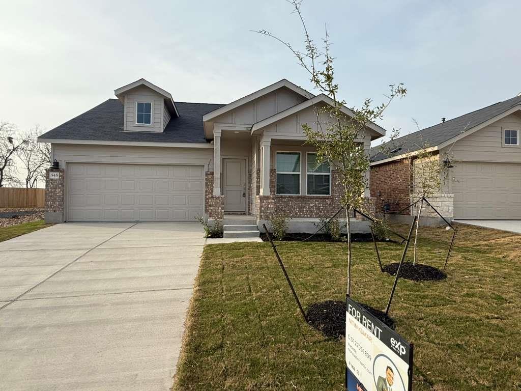 View of front of property with a front yard, bric