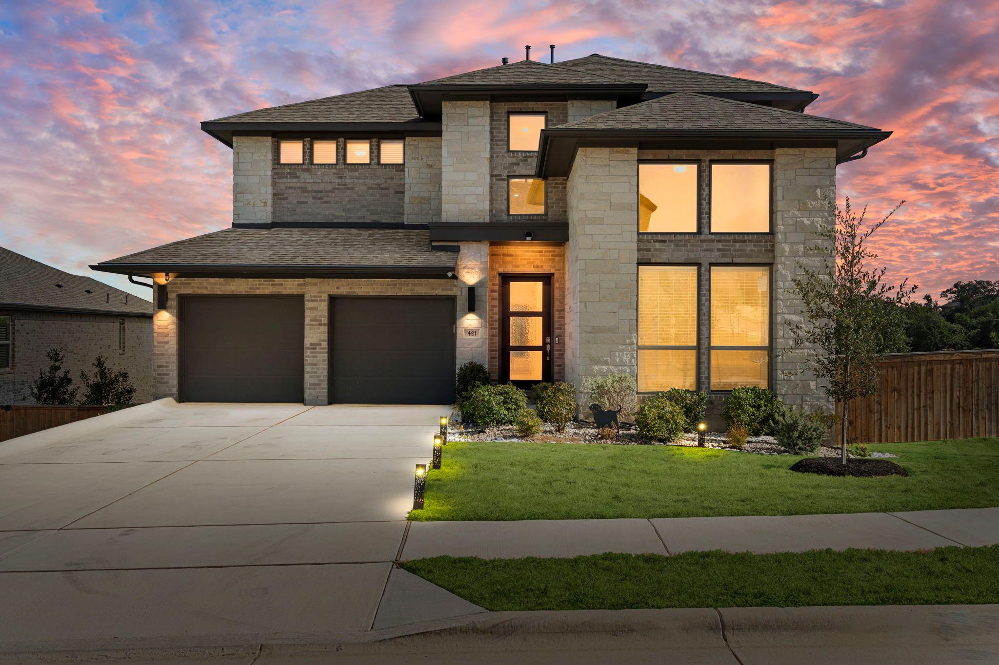 Dramatic sunset skies frame a modern stone facade