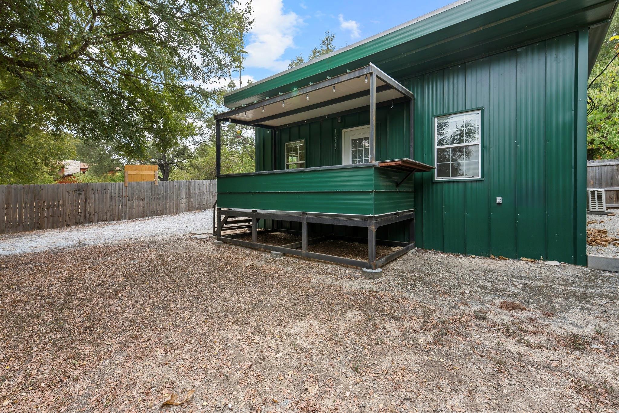 A raised porch with a metal roof shelters the ent