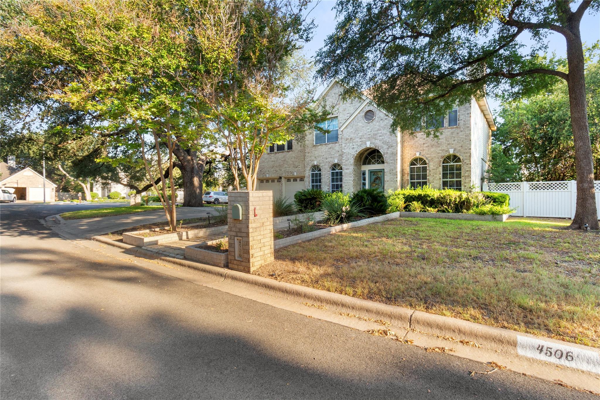 Mature trees frame a classic brick exterior with 