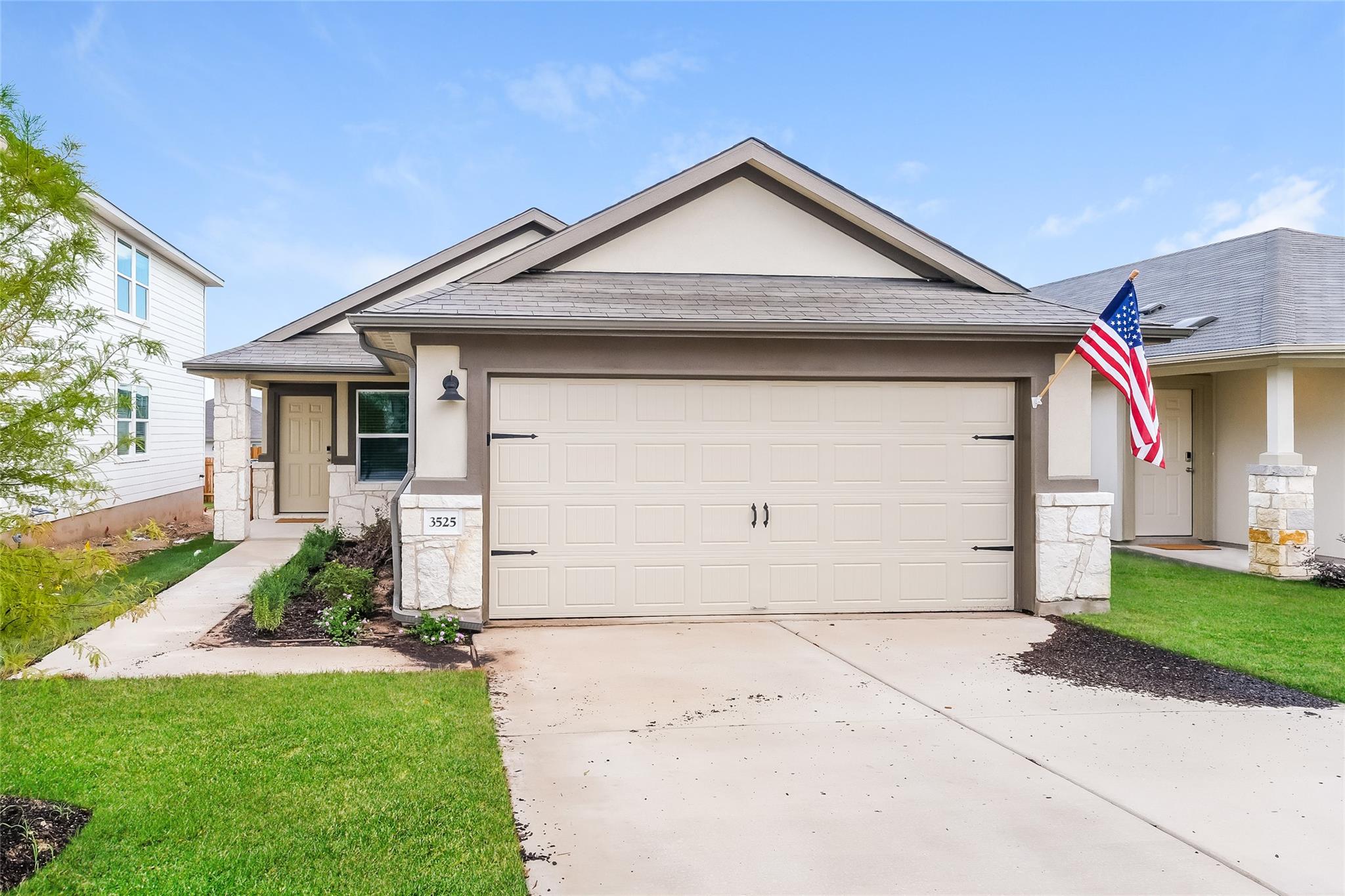 An inviting exterior features a concrete driveway