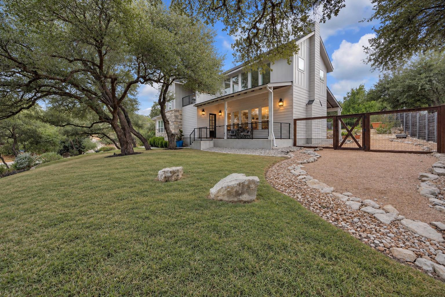 Mature trees shade a manicured lawn leading up to